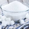 a bowl of sugar surrounded by cubes of sugar