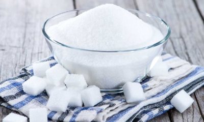 a bowl of sugar surrounded by cubes of sugar