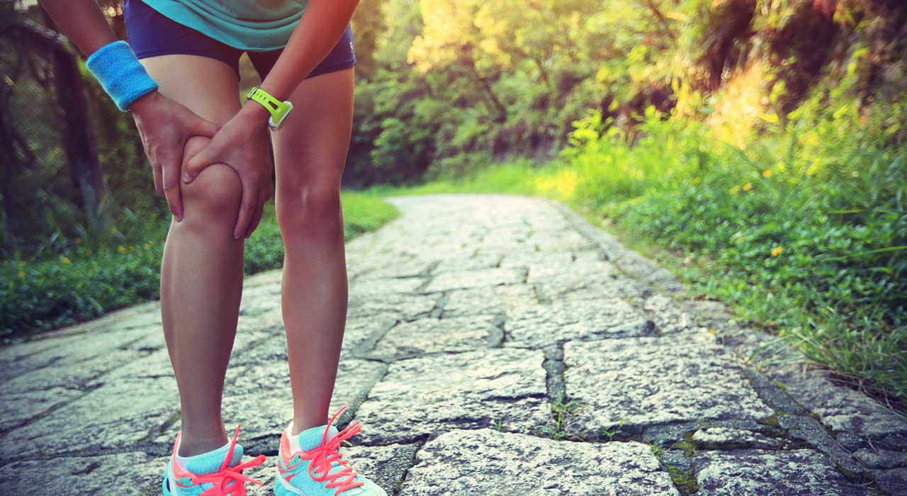 runner holding her knee due to an injury