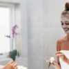 woman in a bathroom applying a face mask