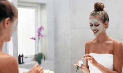 woman in a bathroom applying a face mask