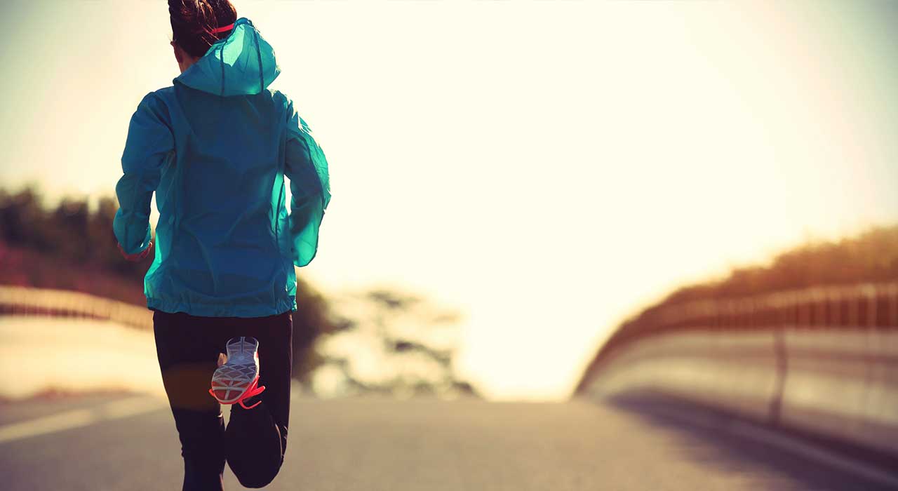 a woman running along an empty road