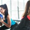 two fit women performing abs exercises in a gym studio