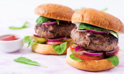 two burgers side by side next to a pot of sauce