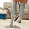 a woman hoovering her living room carpet