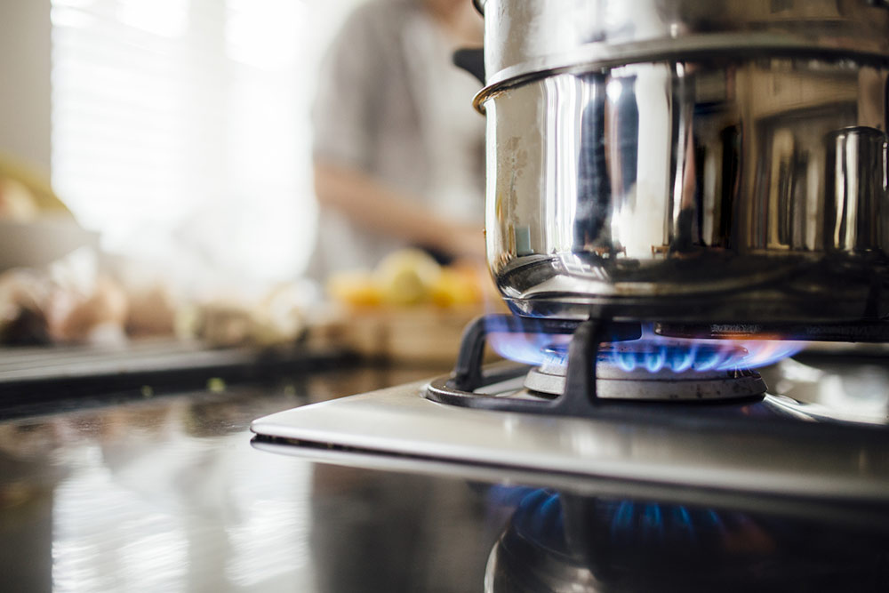 a silver pan on a gas stove