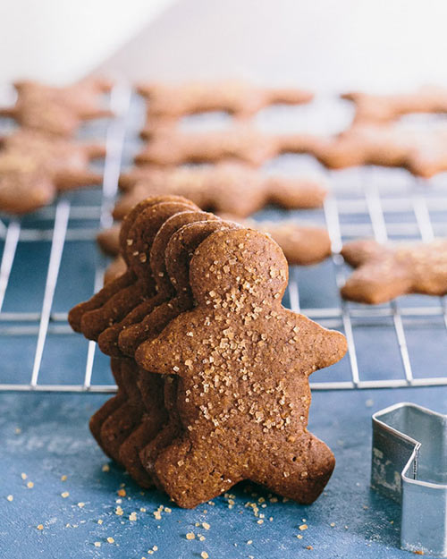 baking tray with gingerbread men on and a stack of gingerbread men stood up