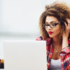 woman on her laptop wearing a checkered shirt