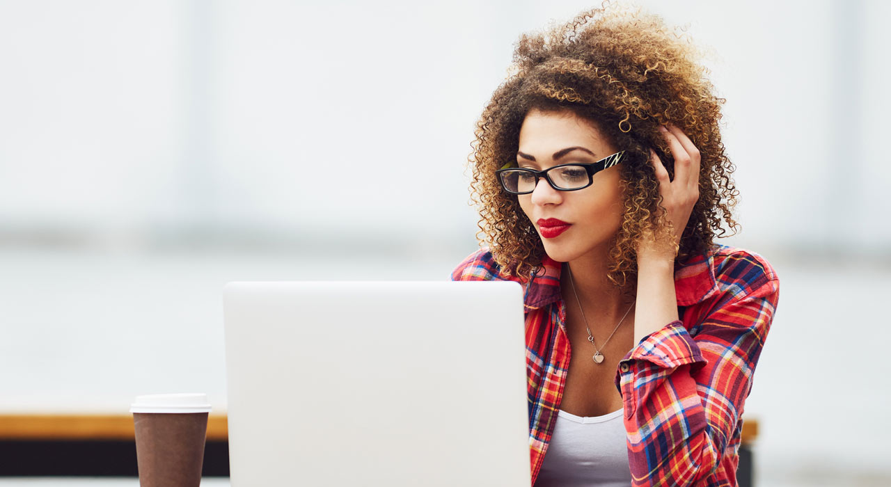 woman on her laptop wearing a checkered shirt