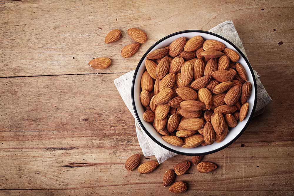 bowl of almond nuts on a wooden table