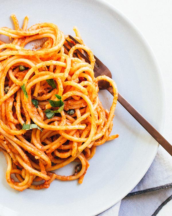 marinara pasta on a white plate with a silver fork