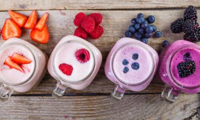 four different berry smoothies lined up next to eachother