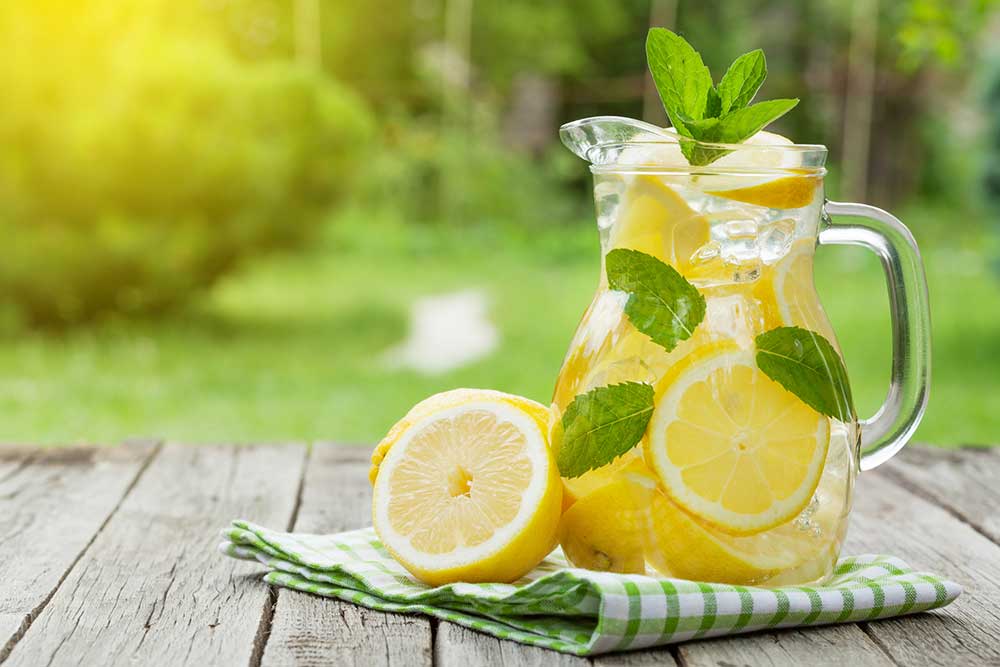 lemon water in a jug with lemon slices