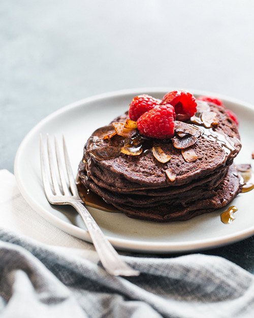 Chocolate Brownie Spelt Vegan Pancakes on a white plate with a silver fork
