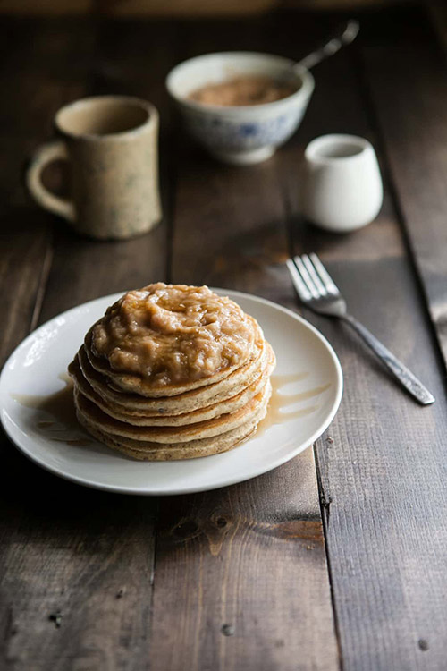 Hazelnut Pancakes With Roasted Rhubarb Cardamom Compote on a wooden table