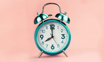 an alarm clock on a pink background