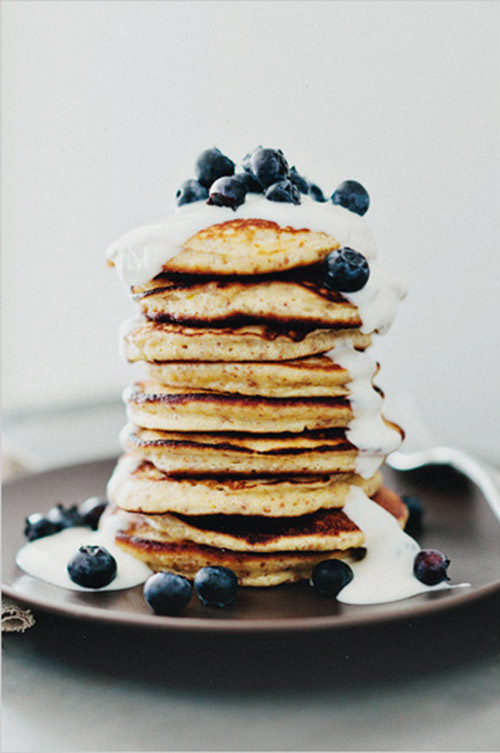 Lemon pancakes with yogurt and berries on a brown plate