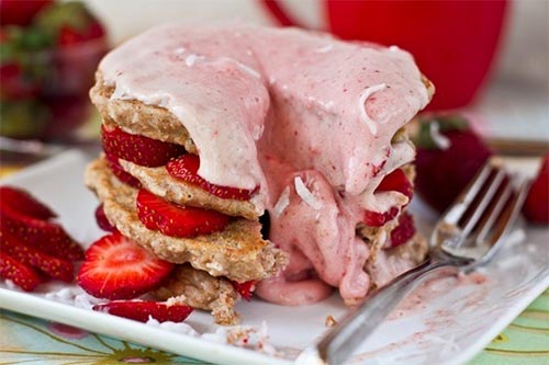 strawberry shortcake stacked pancakes on a white plate with a fork