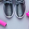 running shoes next to a pair of dumbbells and skipping ropes