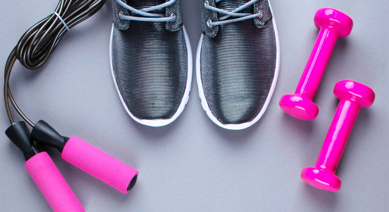 running shoes next to a pair of dumbbells and skipping ropes