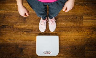 a woman in grey pants and pink tshirt stood next to some scales