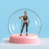 a fit woman performing exercises in a snow globe