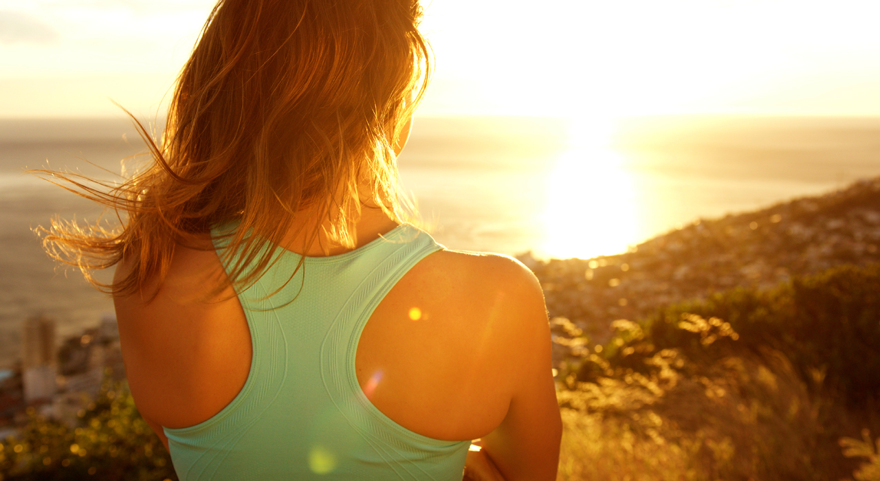 a woman standing looking into the sun