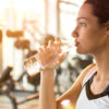 woman sipping water in the gym