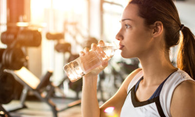 woman sipping water in the gym