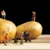 miniature builder figures working around two potatoes