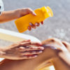 woman putting on sunscreen