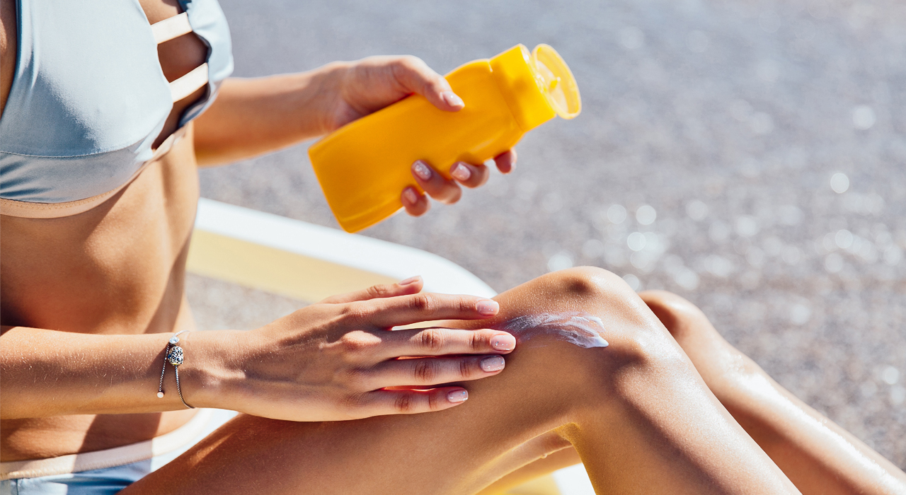 woman putting on sunscreen