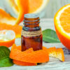 sweet orange essential oil bottle surrounded by orange peel and orange