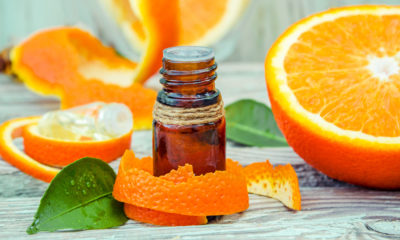 sweet orange essential oil bottle surrounded by orange peel and orange