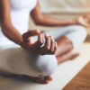 a woman meditating on a cream mat