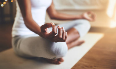 a woman meditating on a cream mat