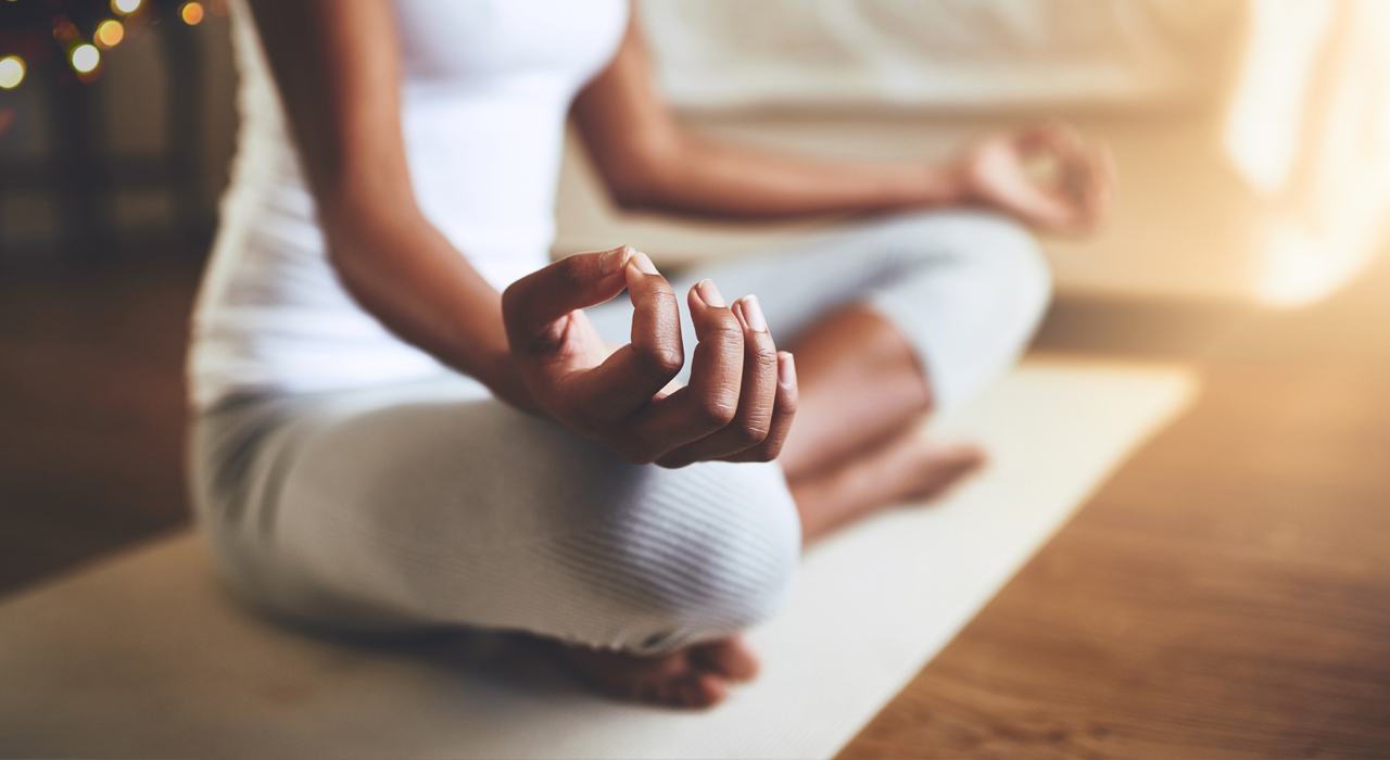 a woman meditating on a cream mat