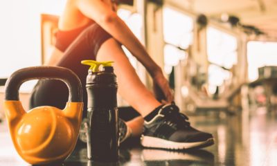 woman sitting down in a gym next to a waterbottle and kettlebell