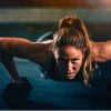 ginger woman performing push ups with dumbbells