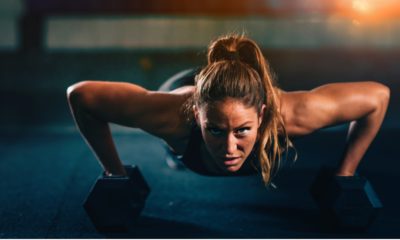 ginger woman performing push ups with dumbbells