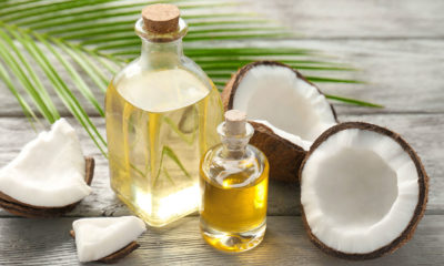 coconut oil in a small flask surrounded by a broken coconut