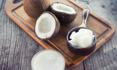 split coconuts on a chopping board and a mini saucepan full of coconut chunks