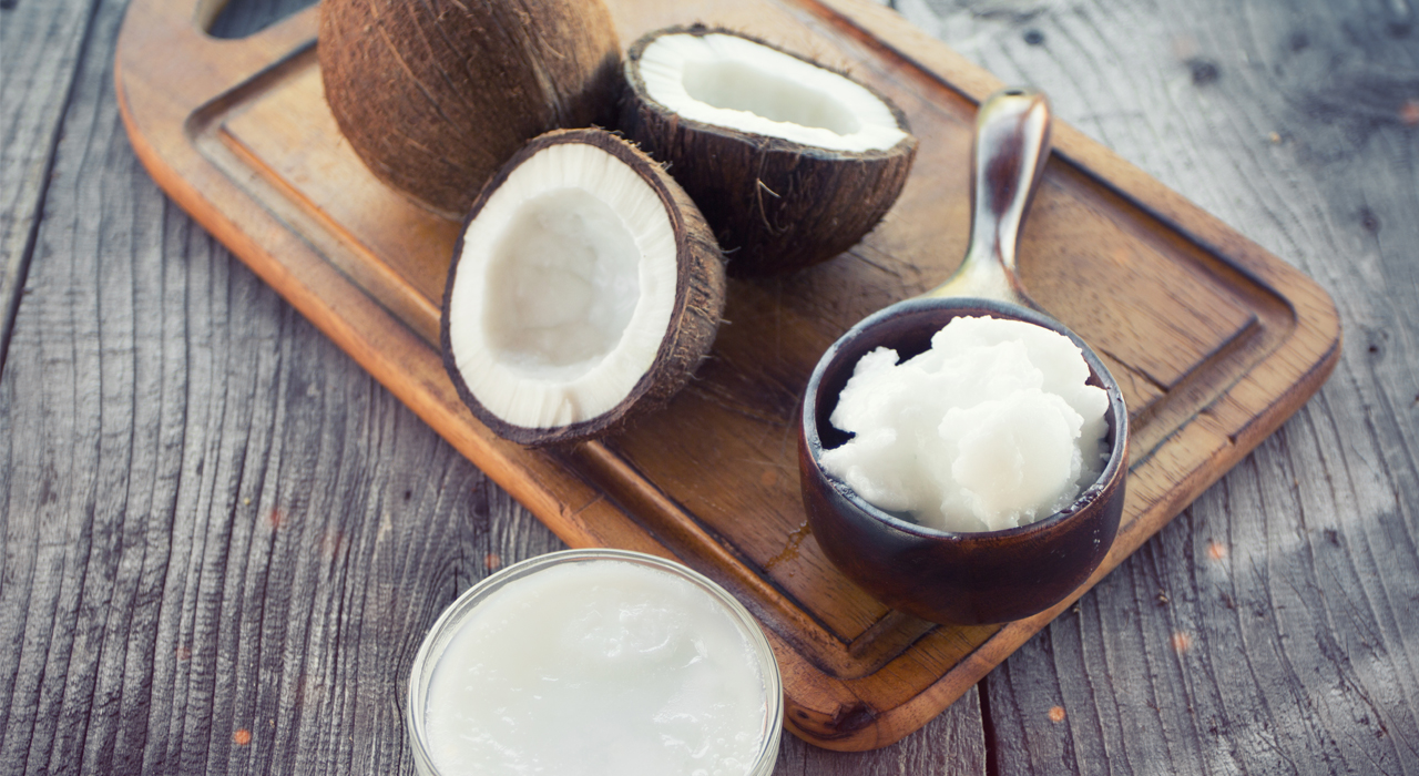 split coconuts on a chopping board and a mini saucepan full of coconut chunks