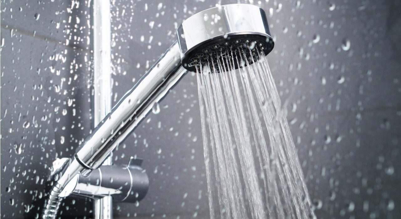 a silver shower head spurting out water