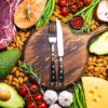 chopping board with a knife and fork on surrounded by food