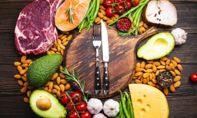 chopping board with a knife and fork on surrounded by food