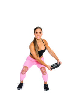 fit woman performing a squat with woodchop