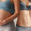 a pregnant woman next to a fit woman