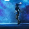 woman skipping in a room with blue lighting
