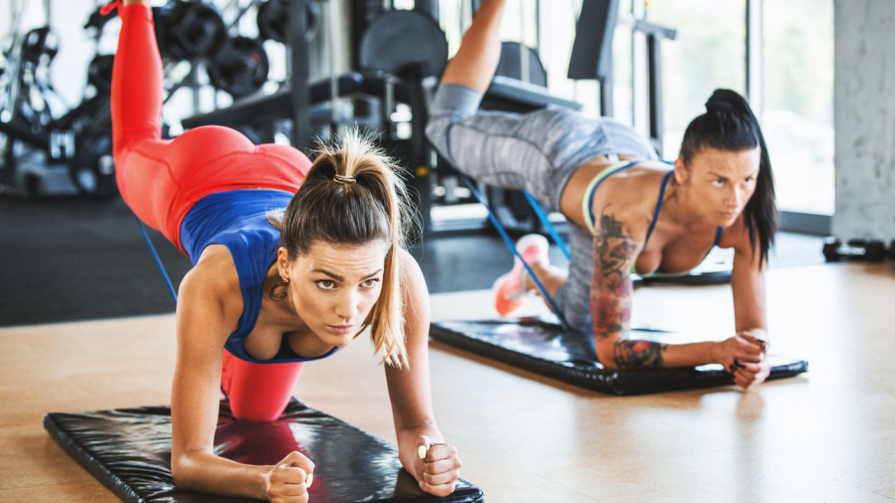 two young fit women performing glute exercises